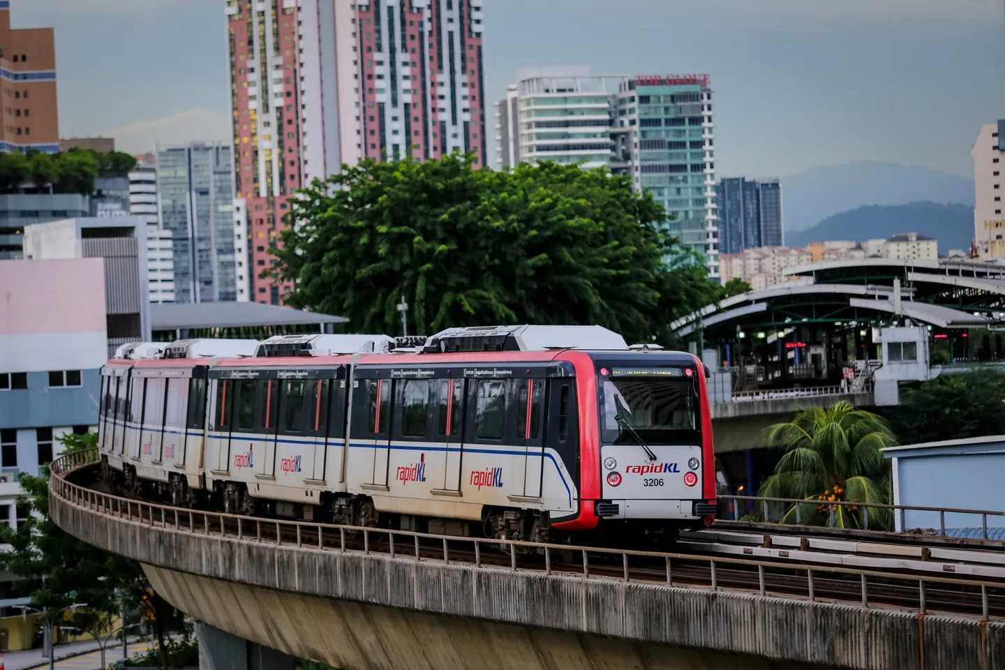Ampang Line LRV on the elevated viaduct through the KL cityscape