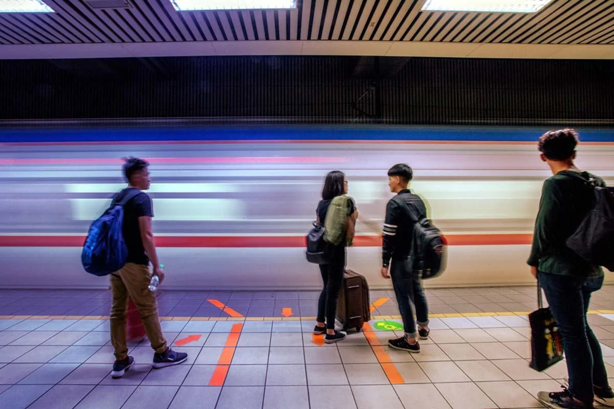 Passengers waiting as a train passes a platform